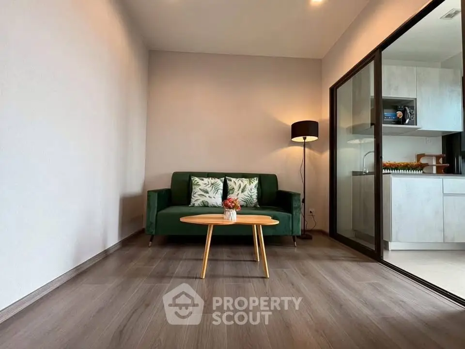 Modern living room with green sofa and open kitchen layout