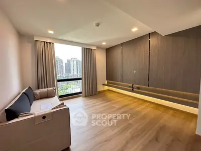 Spacious modern living room with large window and city view, featuring sleek wood flooring and minimalist design.