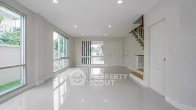 Spacious modern living room with large windows and glossy floors