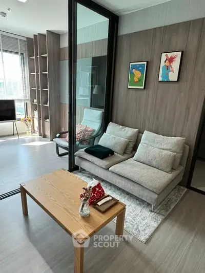 Modern living room with stylish decor and natural light, featuring a cozy sofa and elegant wooden coffee table.