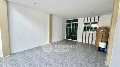 Spacious tiled area with water tank, ideal for storage or utility use.