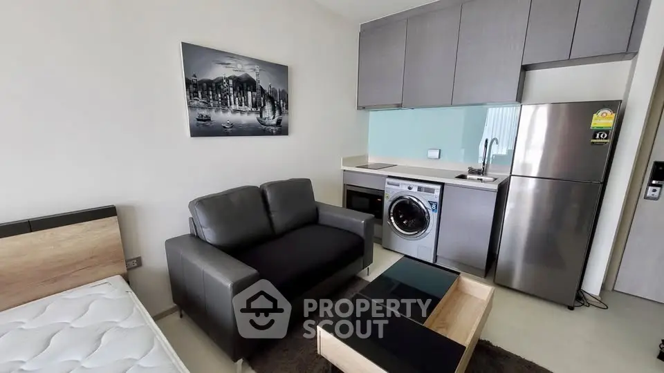 Modern studio apartment with compact kitchen and stylish living area