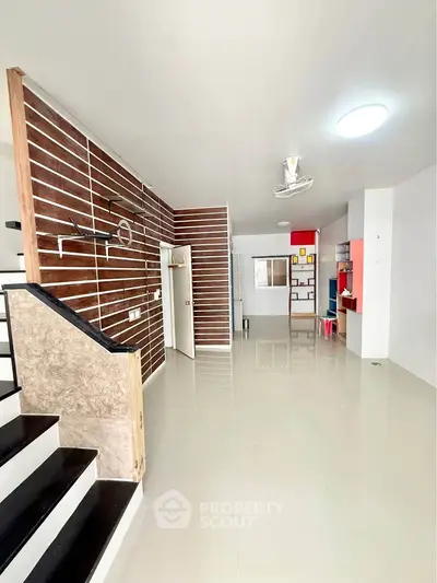 Spacious modern living room with sleek staircase and stylish wooden accents