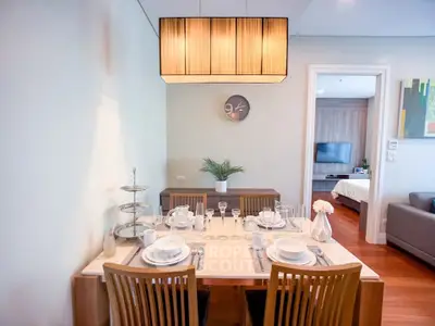 Elegant dining area with modern decor and open view to living room and bedroom, perfect for stylish urban living.
