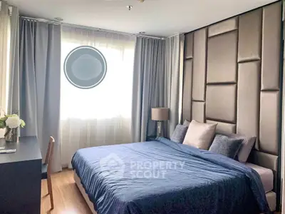 Luxurious bedroom with elegant decor and large window in modern apartment.