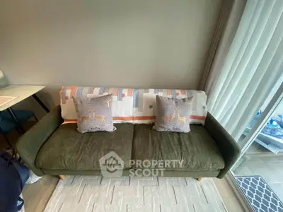 Cozy living room with stylish green sofa and decorative pillows, perfect for relaxation.