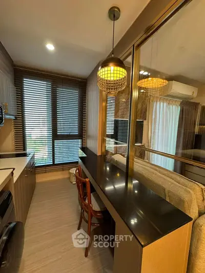 Modern kitchen with sleek design and open layout, featuring stylish lighting and large windows for natural light.