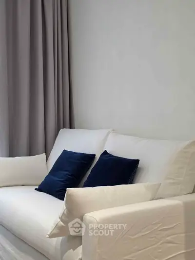 Elegant living room with white sofa and blue cushions, perfect for modern interiors.