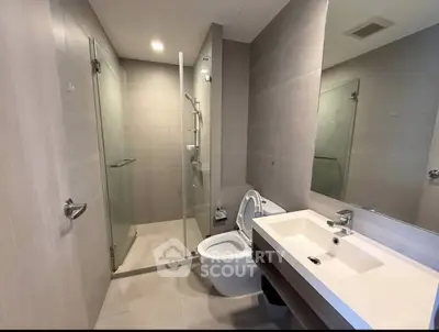 Modern bathroom with glass shower and sleek fixtures in a contemporary apartment.