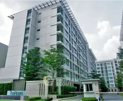 Modern residential building exterior with lush greenery and contemporary design.