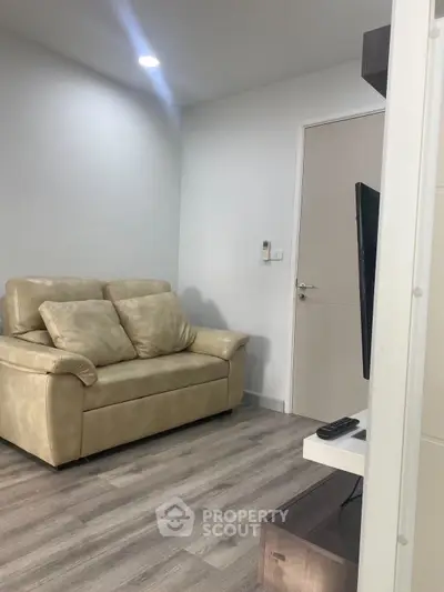 Cozy living room with modern sofa and sleek TV setup, perfect for relaxation.