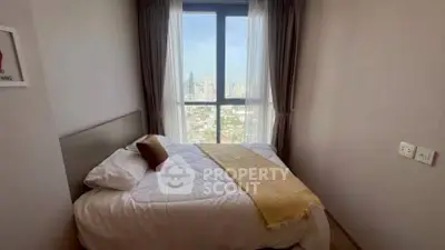 Cozy bedroom with city view and large window, perfect for relaxation.