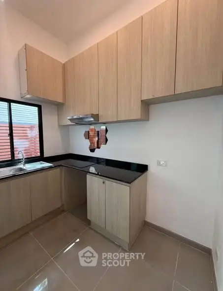 Modern kitchen with sleek wooden cabinets and black countertops