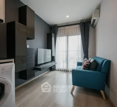 Modern living room with sleek design, featuring a blue sofa, wall-mounted TV, and large window with curtains.