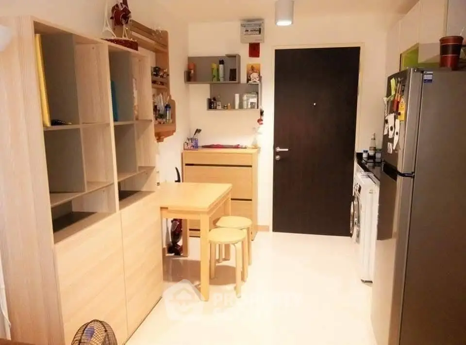 Cozy kitchen with modern appliances and wooden furniture, ideal for compact living spaces.