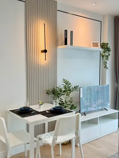 Modern living room with stylish decor, dining table, and TV unit in a cozy apartment setting.