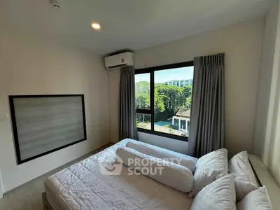 Cozy bedroom with large window offering a serene garden view, featuring modern air conditioning and elegant curtains.