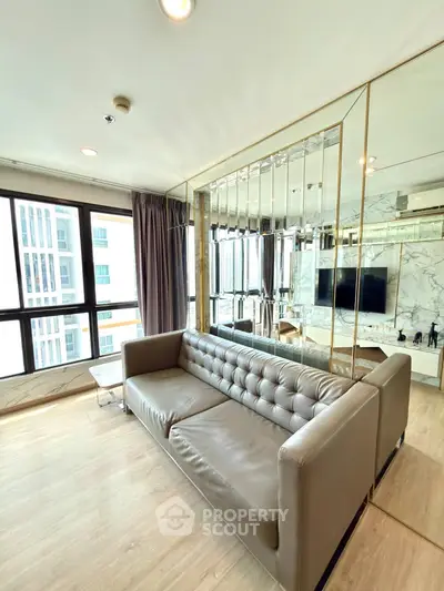 Luxurious living room with modern decor and stunning city view, featuring a plush leather sofa and mirrored accents.