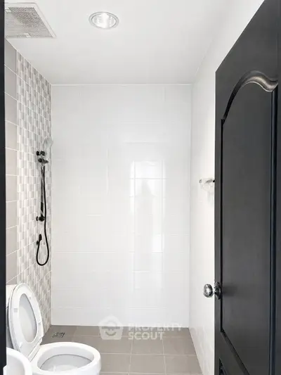 Modern minimalist bathroom with sleek black door and stylish shower design.