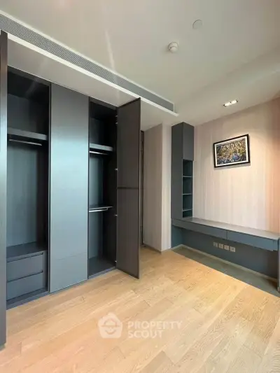 Spacious modern bedroom with built-in wardrobe and sleek wooden flooring