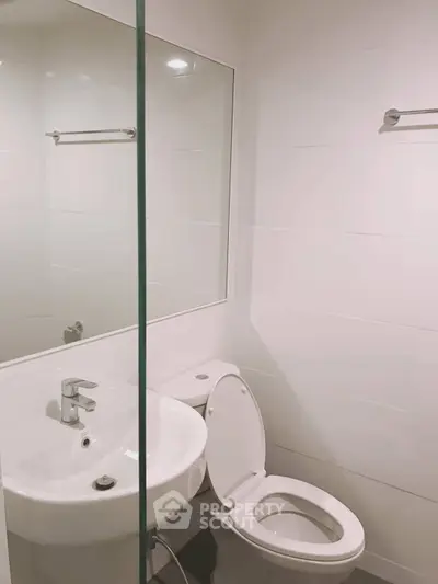 Modern bathroom with sleek white fixtures and minimalist design.