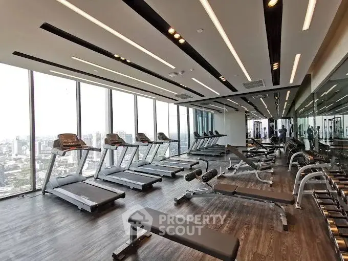 Luxurious high-rise gym with panoramic city views and modern equipment.