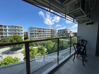 Modern balcony with scenic view of contemporary apartment buildings and lush greenery.