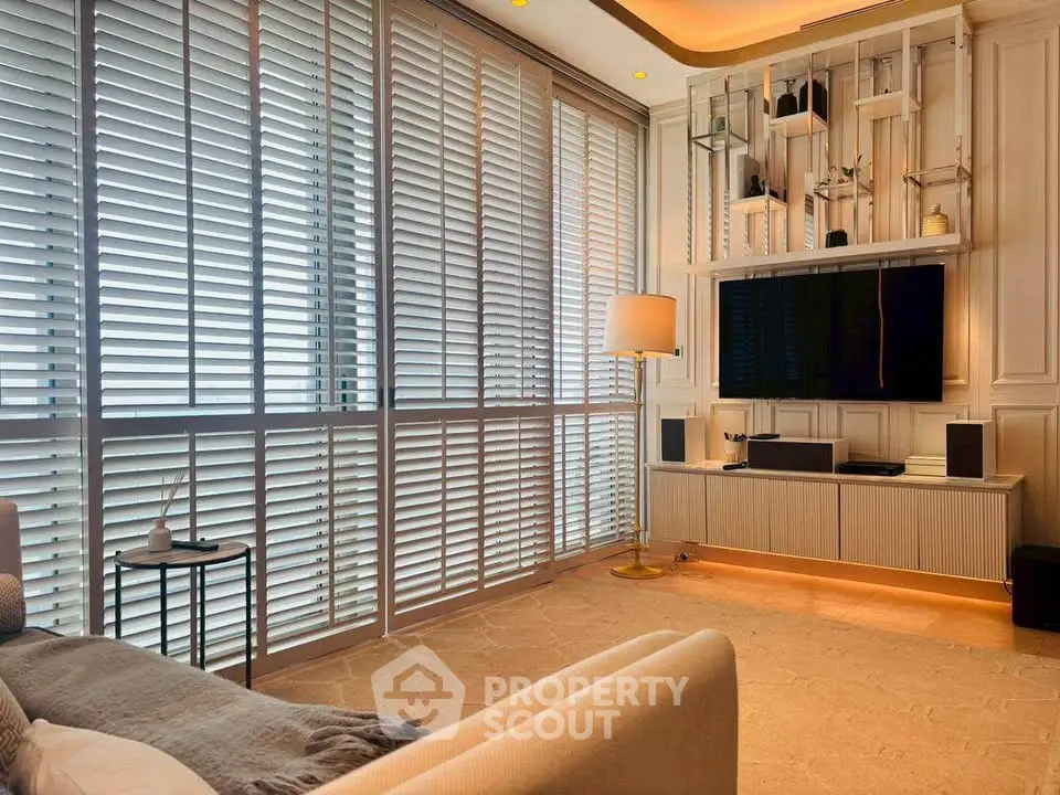 Luxurious living room with modern decor and large windows with blinds