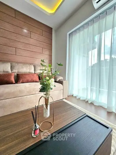 Modern living room with elegant decor and large window for natural light.