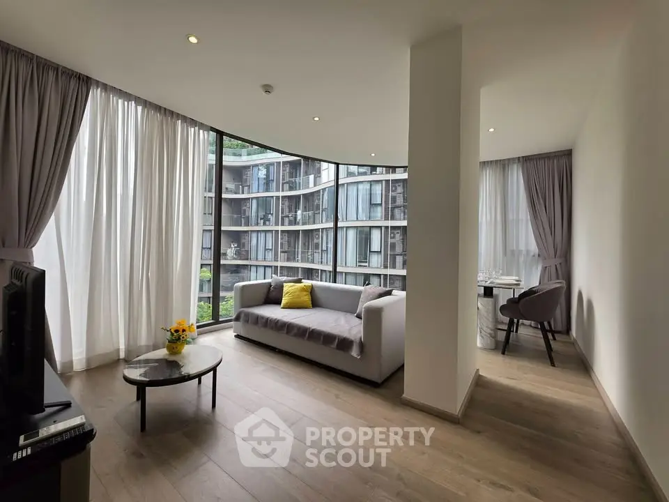 Spacious modern living room with floor-to-ceiling windows and elegant decor in a luxury apartment.