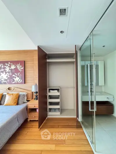 Modern bedroom with open closet and glass partitioned bathroom