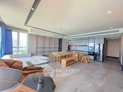 Spacious modern living room with open kitchen and panoramic city view.