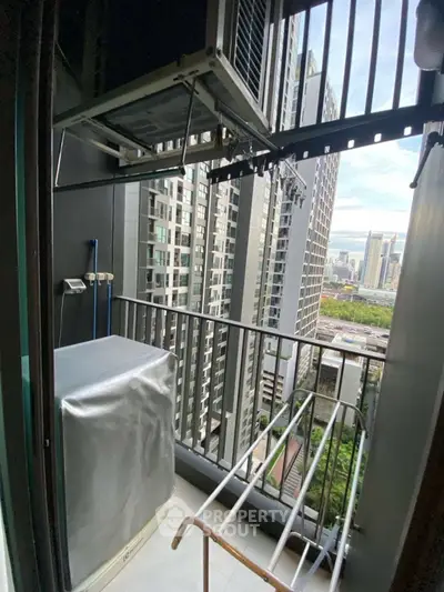 High-rise apartment balcony with city view and laundry area