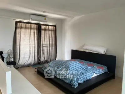 Spacious bedroom with modern platform bed and large windows for natural light.