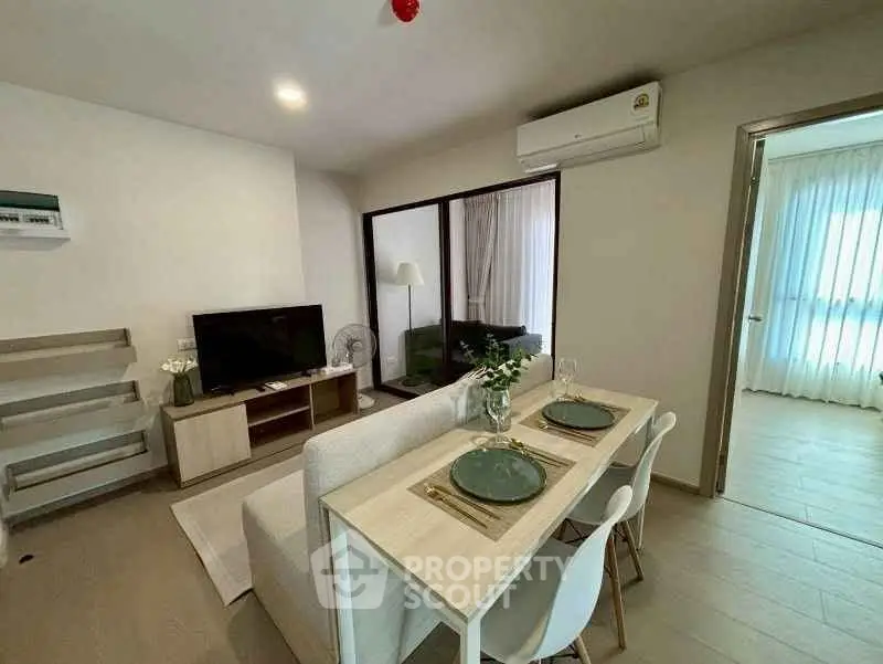 Modern living room with dining area and air conditioning in a stylish apartment.