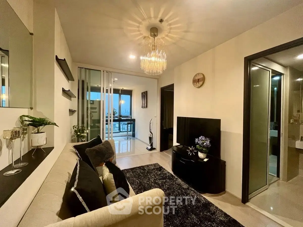 Stylish modern living room with elegant chandelier and balcony view