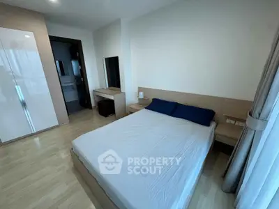Modern bedroom with sleek wooden furniture and large window for natural light.