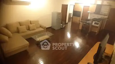Spacious living room with modern kitchen and cozy sofa in open layout apartment.