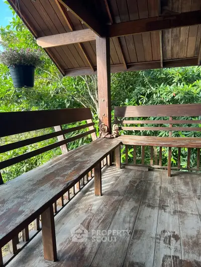 Charming wooden balcony with lush greenery, perfect for relaxation and nature lovers.