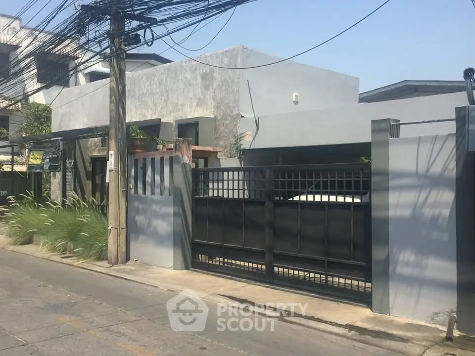 Modern residential building with gated entrance and minimalist design in urban setting.