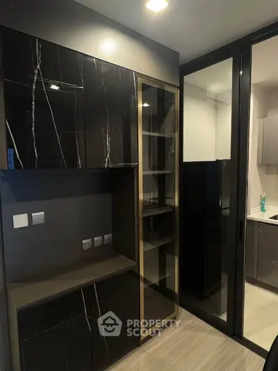 Modern kitchen with sleek black cabinetry and glass door design