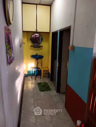 Cozy hallway with colorful walls and a small sink, ideal for compact living spaces.
