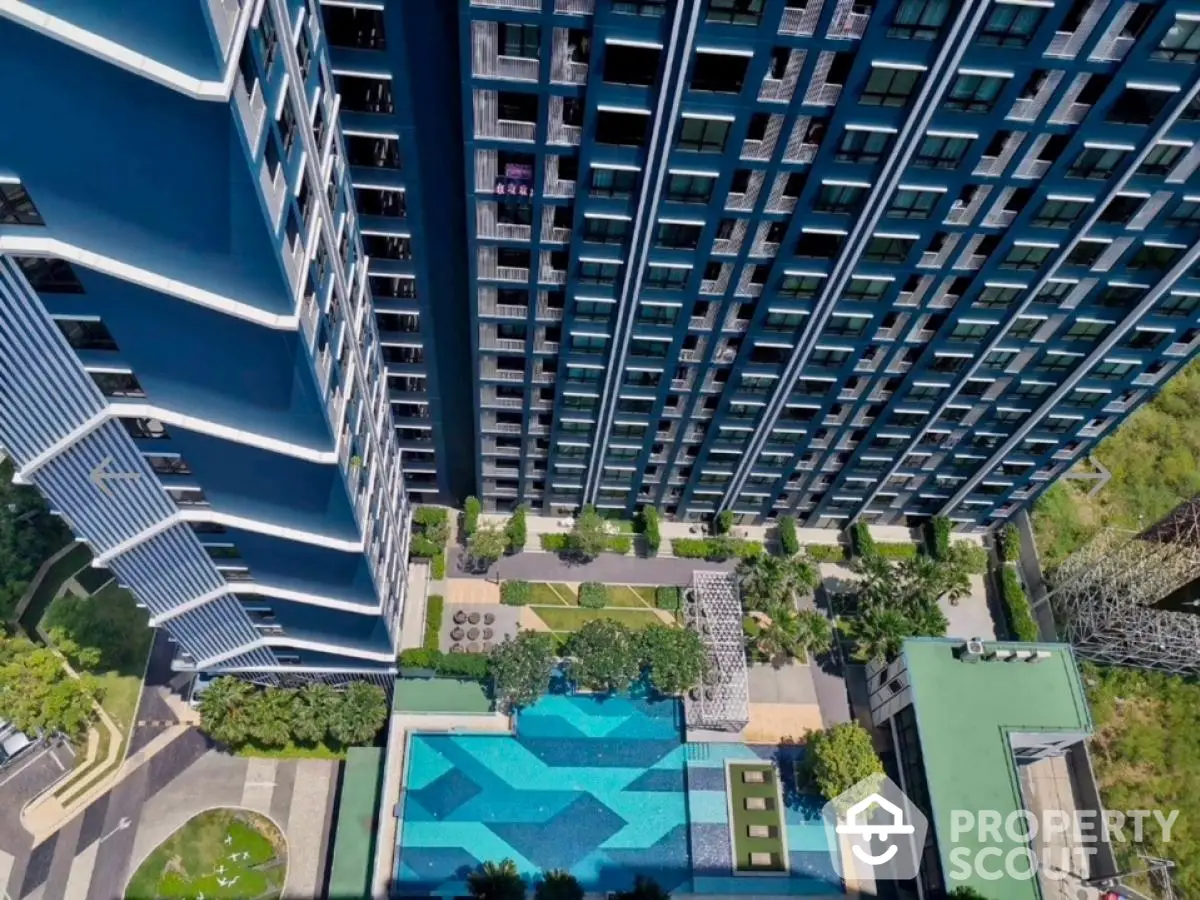 Stunning aerial view of modern high-rise building with luxurious swimming pool and landscaped garden.