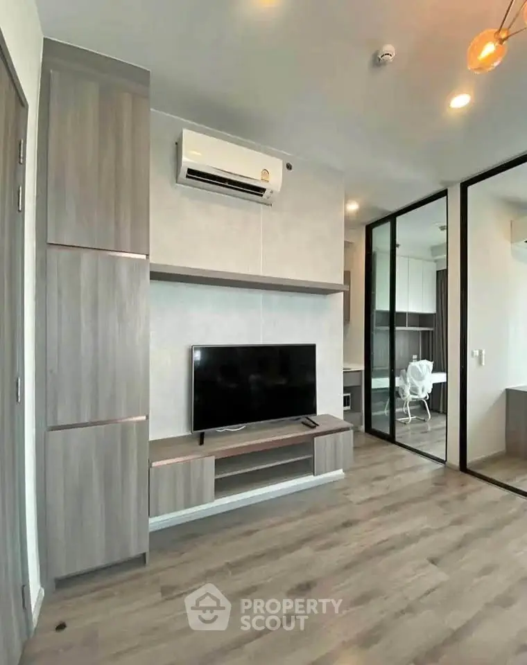 Modern living room with sleek design, featuring a mounted TV and air conditioning, perfect for urban living.