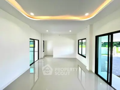 Spacious modern living room with large windows and sleek lighting