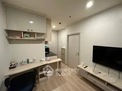 Modern apartment interior with sleek furniture and wall-mounted TV, showcasing a compact and efficient living space.