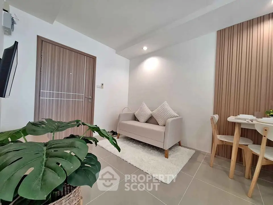 Modern living room with cozy sofa and dining area, featuring stylish decor and natural light.