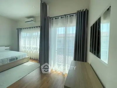 Bright bedroom with large windows and modern furnishings, perfect for natural light lovers.