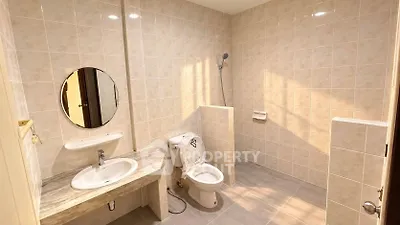 Spacious bathroom with modern fixtures and tiled walls in a real estate property.