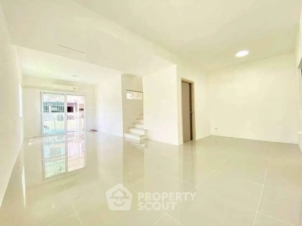 Spacious modern living room with glossy tiled floors and bright natural light.